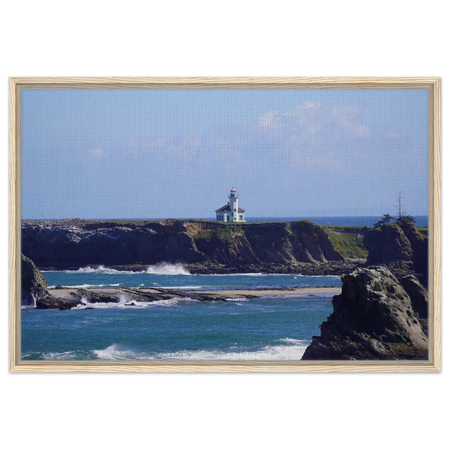 Cape Arago Lighthouse on the Oregon coast beyond rocky shoreline and blue Pacific water as canvas wall art.