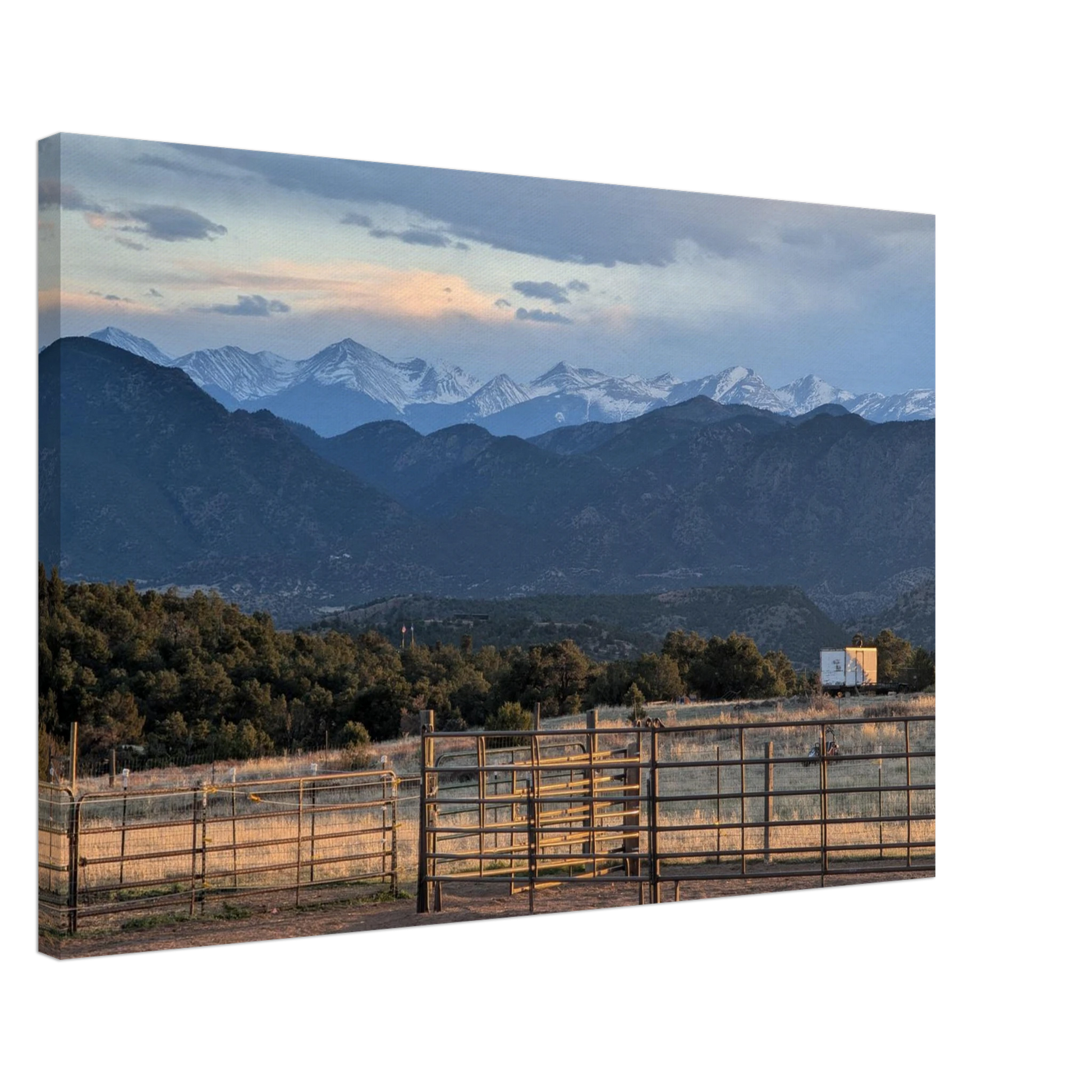 Ranch gate and fencing beneath snow-capped Rocky Mountains in warm evening light as canvas wall art.