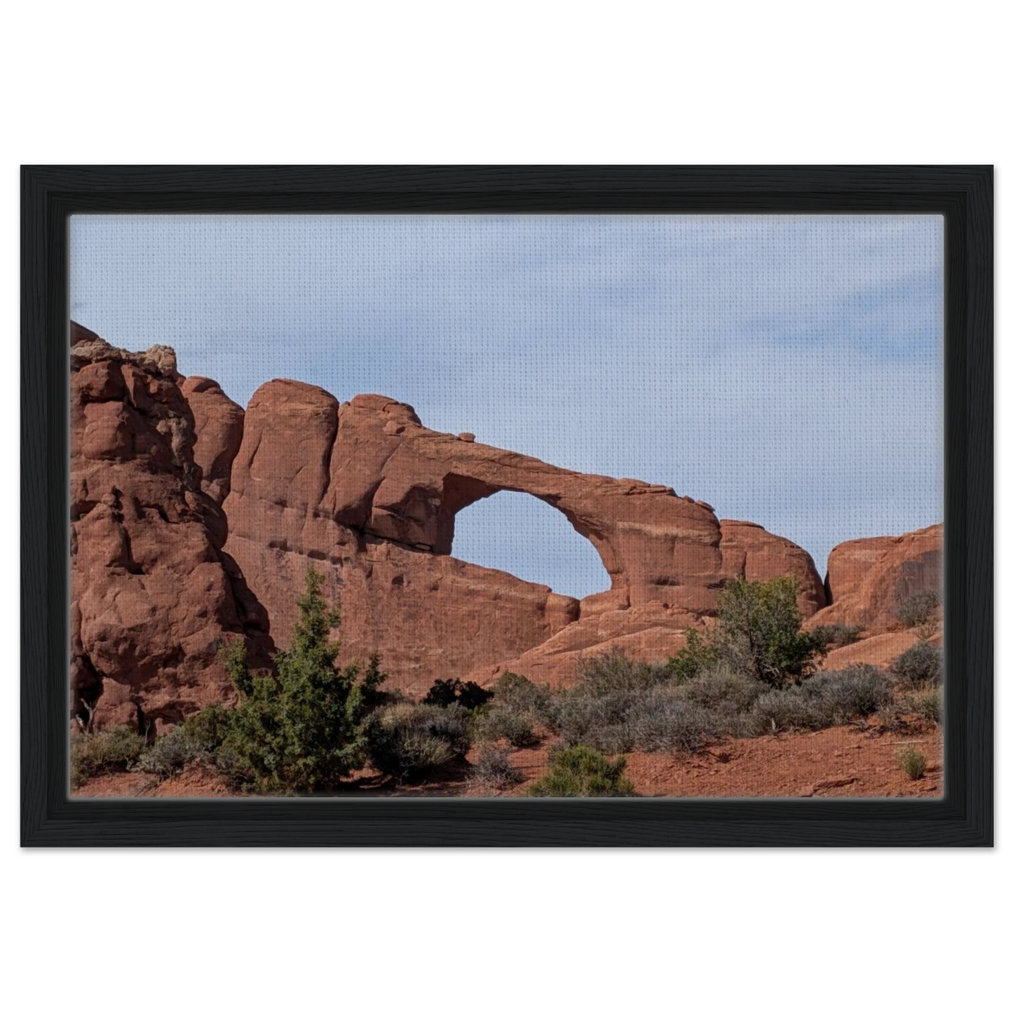 Skyline Arch in Arches National Park framed by red sandstone as desert canvas wall art.